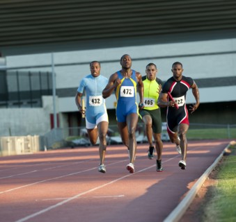 Relay racers running on track in race