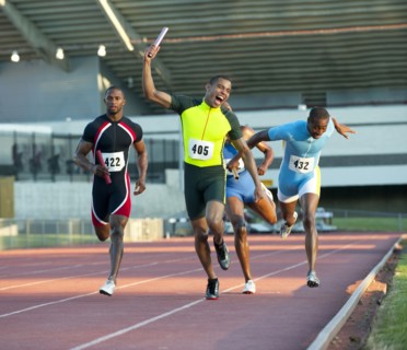 Relay racer crossing finish line on track in race