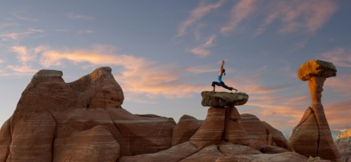 Caucasian woman practicing yoga on top of rock formation