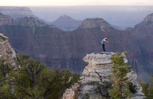 Caucasian woman practicing yoga on top of rock formation