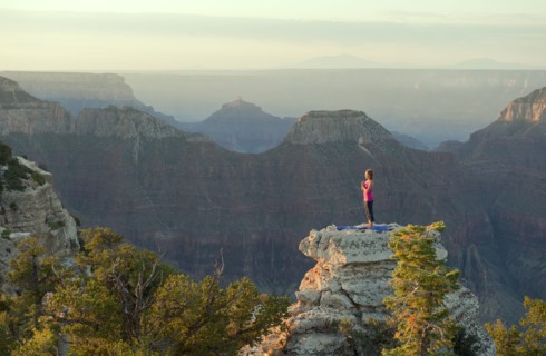 Caucasian woman practicing yoga on top of rock formation
