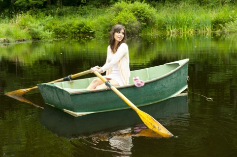 Caucasian woman rowing boat in pond