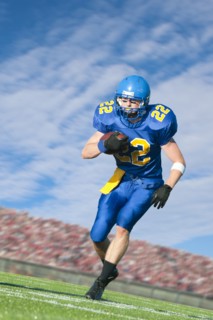 Caucasian football player running with ball