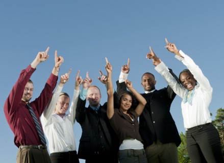 Business people standing together with arms raised