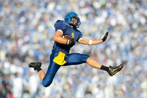 Caucasian football player running with football