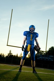 Caucasian football player standing with football