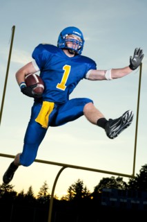 Caucasian football player running with football