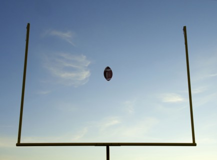 Football being thrown through goal posts