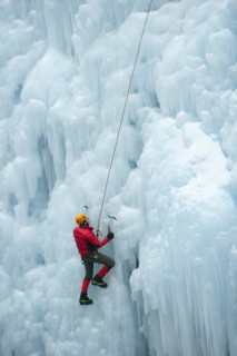 Caucasian man climbing ice wall
