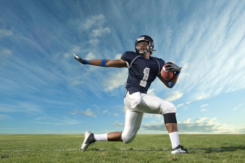 African American football player poised on field