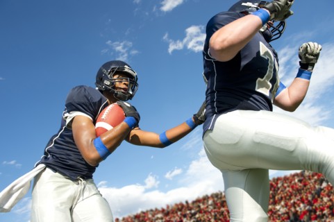 Football players passing ball