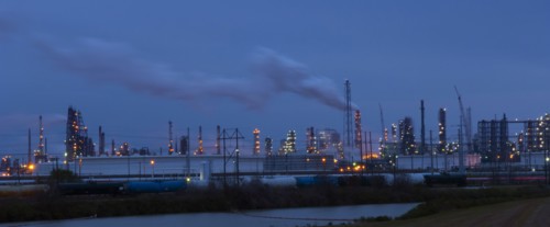 Factory near lake illuminated at night
