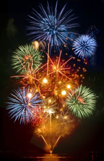 Fireworks exploding over cruise ship in harbor
