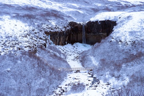 Waterfall and river in snowy landscape