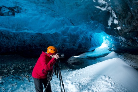 Photographer taking photograph in ice cave