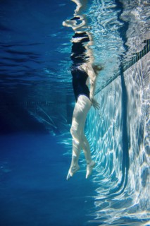 Teenage girl swimming underwater in pool