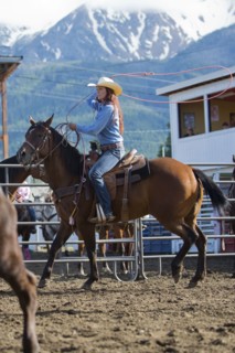Caucasian cowgirl riding horse in rodeo on ranch