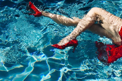 Legs of woman wearing high heels in swimming pool