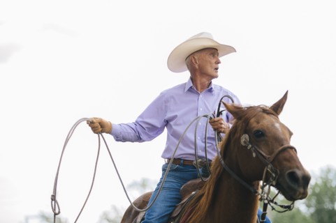 Caucasian cowboy riding horse in rodeo