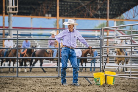 Caucasian cowboy standing at rodeo fence