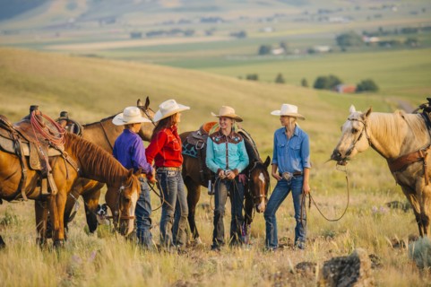 Cowboy and cowgirls with horses on ranch