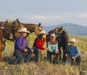 Cowboy and cowgirls with horses on ranch