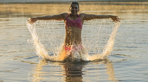 Mixed Race woman splashing in lake