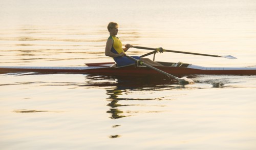 Caucasian man rowing on lake