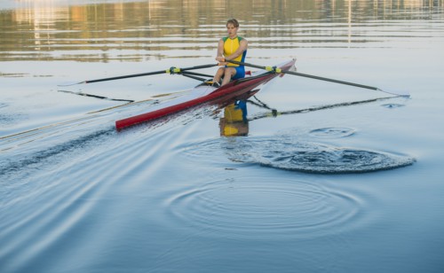Caucasian man rowing on lake