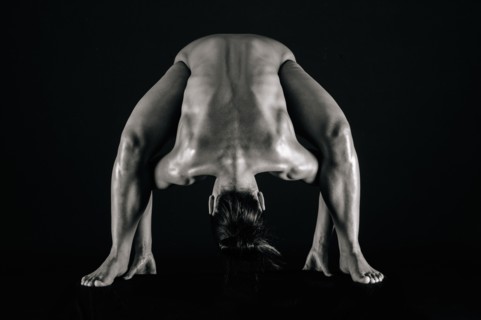 Naked muscular Mixed Race woman bending forward