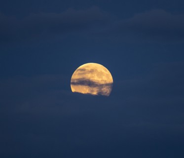 Clouds in sky in front of full moon