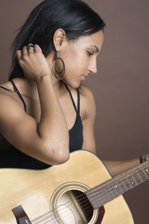 Mixed Race woman holding guitar