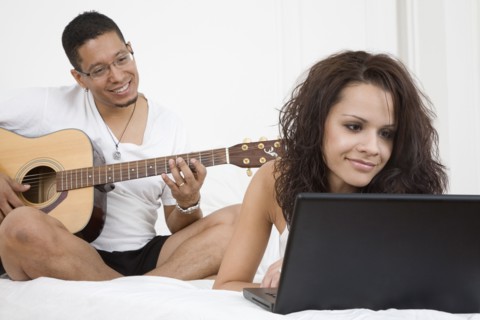 Hispanic couple relaxing on bed
