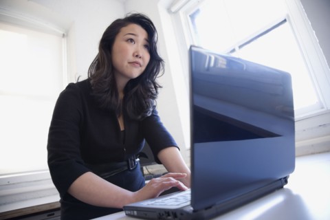 Asian businesswoman typing on laptop