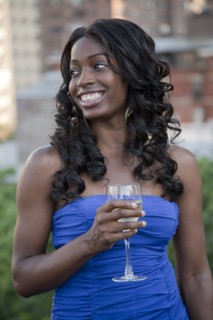 Glamorous African American woman drinking wine outdoors
