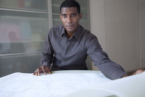 Black businessman reviewing blueprints