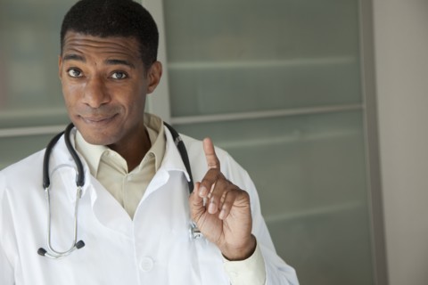 Black doctor in lab coat with hand raised