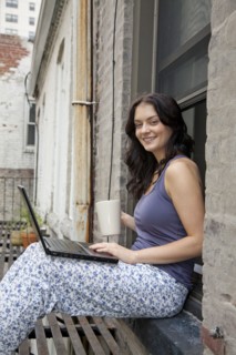 Woman using laptop on fire escape