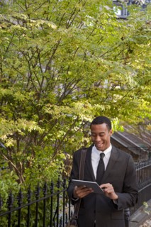 Black businessman using digital tablet outdoors