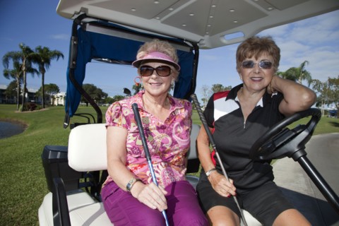 Senior Caucasian woman riding in golf cart