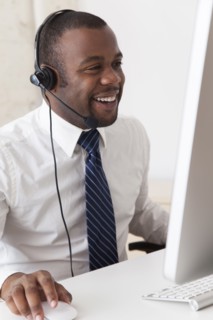 Black businessman in headset working at desk