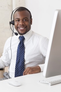 Black businessman in headset working at desk