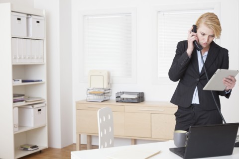 Caucasian businesswoman talking on phone in office
