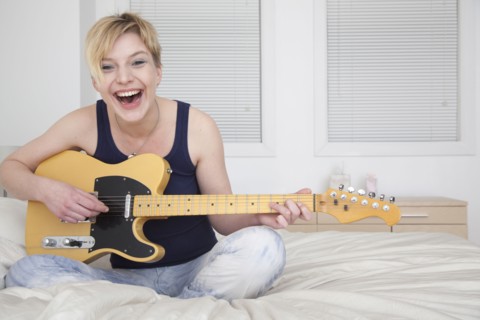 Caucasian woman playing electric guitar