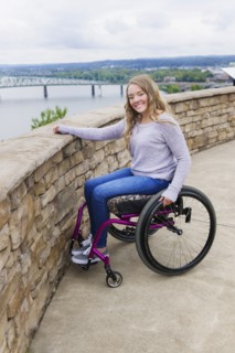 Caucasian disabled girl in wheelchair overlooking Columbus cityscape
