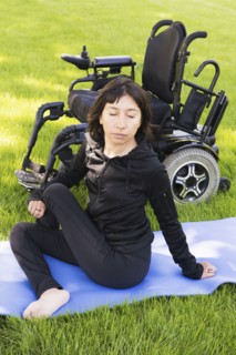 Disabled woman stretching legs in park