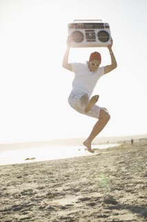 Hispanic man holding boom box and jumping