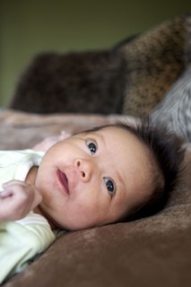 Mixed race newborn baby laying on blanket