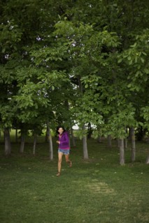 Hispanic woman running through park