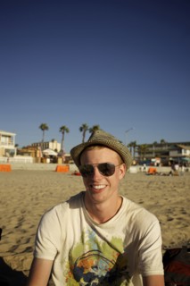 Smiling Caucasian man sitting on beach